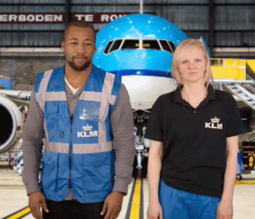 A Man And A Woman Are Standing In Front Of A Klm Airplane GIF
