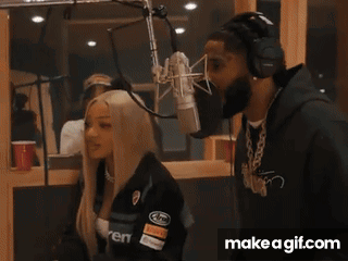 A Man And A Woman Are Standing In Front Of A Microphone With Make A Gif.com In The Corner GIF