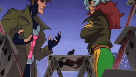 A Man And A Woman Are Standing In Front Of A Pile Of Playing Cards One Of Which Has The Number 4 On It GIF