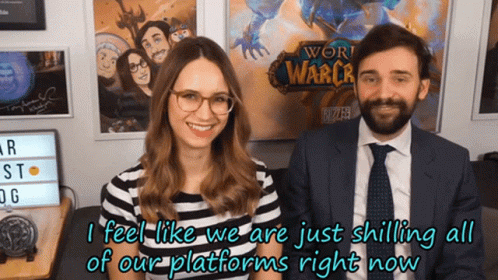 A Man And A Woman Are Standing In Front Of A Poster For World Of Warcraft GIF