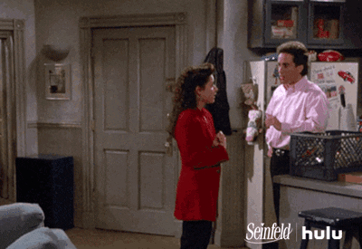 A Man And A Woman Are Standing In Front Of A Refrigerator That Says Seinfeld GIF
