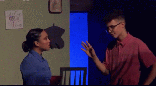 A Man And A Woman Are Standing In Front Of A Sign That Says " It 'S For Love " GIF