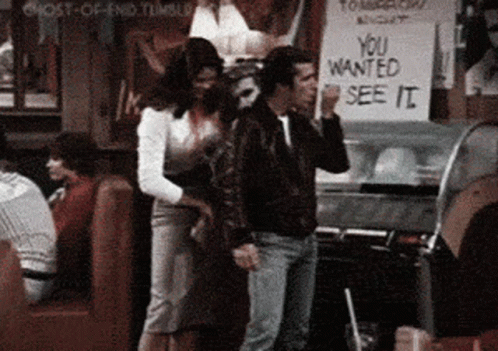 A Man And A Woman Are Standing In Front Of A Sign That Says " You Wanted See It " GIF