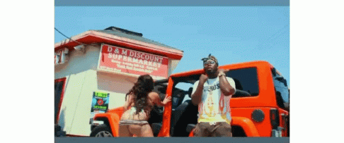 A Man And A Woman Are Standing In Front Of A Store Called D & M Discount GIF