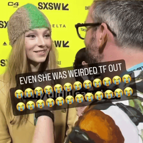 A Man And A Woman Are Standing In Front Of A Yellow Sign That Says Sxsw GIF