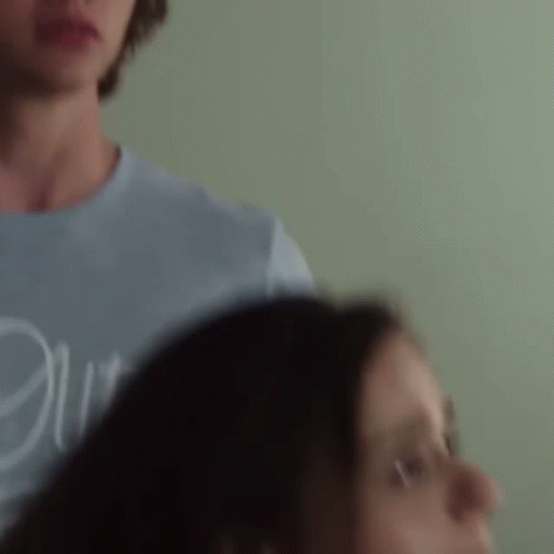 A Man And A Woman Are Standing Next To Each Other . GIF