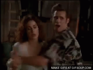 A Man And A Woman Are Standing Next To Each Other And Hugging . GIF