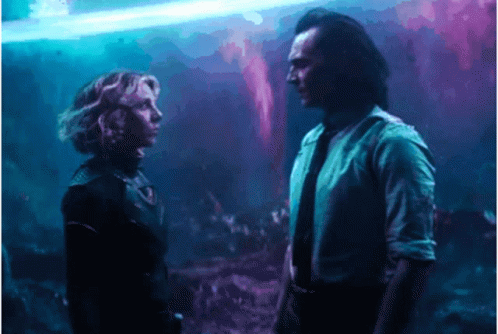 A Man And A Woman Are Standing Next To Each Other And Looking At Each Other . GIF
