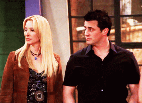 A Man And A Woman Are Standing Next To Each Other And Looking At Each Other GIF