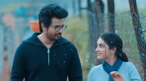 A Man And A Woman Are Standing Next To Each Other And Smiling GIF