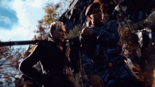 A Man And A Woman Are Standing Next To Each Other And Talking . GIF
