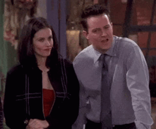 A Man And A Woman Are Standing Next To Each Other And Talking . GIF