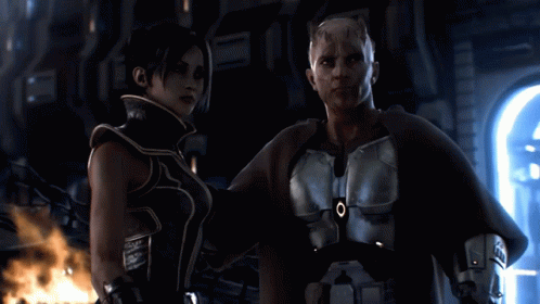 A Man And A Woman Are Standing Next To Each Other And The Man Has An O On His Chest GIF