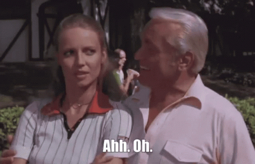 A Man And A Woman Are Standing Next To Each Other And The Man Is Holding The Woman 'S Arm . GIF