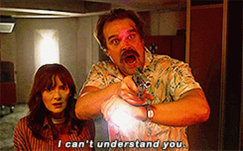 A Man And A Woman Are Standing Next To Each Other And The Man Is Pointing At The Woman . GIF