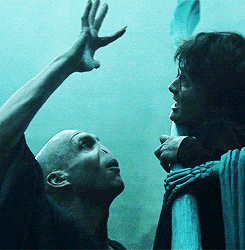A Man And A Woman Are Standing Next To Each Other And The Man Is Reaching Up Towards The Woman GIF