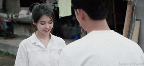 A Man And A Woman Are Standing Next To Each Other And The Man Is Smiling GIF