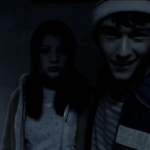 A Man And A Woman Are Standing Next To Each Other And The Man Is Smiling GIF