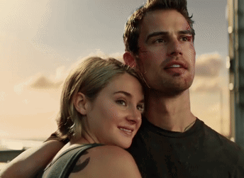 A Man And A Woman Are Standing Next To Each Other And The Woman Has A Tattoo On Her Back GIF