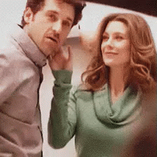 A Man And A Woman Are Standing Next To Each Other And The Woman Is Wearing A Green Shirt GIF