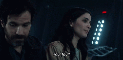 A Man And A Woman Are Standing Next To Each Other And The Woman Says Your Fault GIF