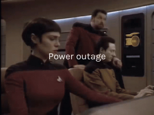 A Man And A Woman Are Standing Next To Each Other And The Words Power Outage Are Displayed Above Them GIF