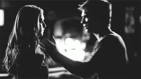 A Man And A Woman Are Standing Next To Each Other And Touching Each Other 'S Faces . GIF