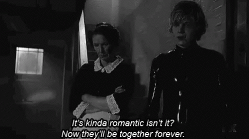 A Man And A Woman Are Standing Next To Each Other In A Black And White Photo . GIF