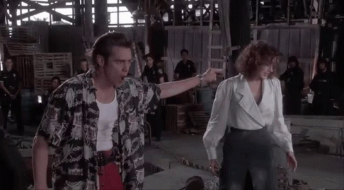 A Man And A Woman Are Standing Next To Each Other In A Building . GIF
