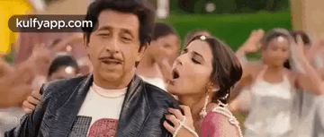 A Man And A Woman Are Standing Next To Each Other In A Crowd Of People . GIF