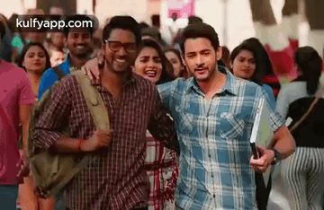 A Man And A Woman Are Standing Next To Each Other In A Crowded Street . GIF
