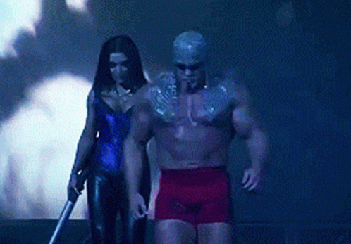 A Man And A Woman Are Standing Next To Each Other In A Dark Room GIF