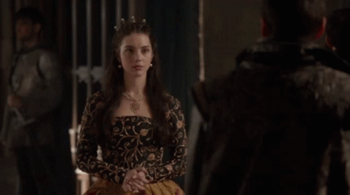 A Man And A Woman Are Standing Next To Each Other In A Dark Room . GIF