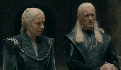 A Man And A Woman Are Standing Next To Each Other In A Dark Room GIF