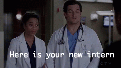 A Man And A Woman Are Standing Next To Each Other In A Hospital Room . GIF