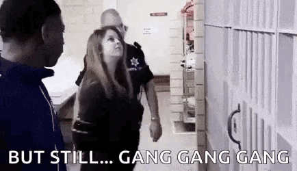 A Man And A Woman Are Standing Next To Each Other In A Jail Cell And Talking To Each Other . GIF