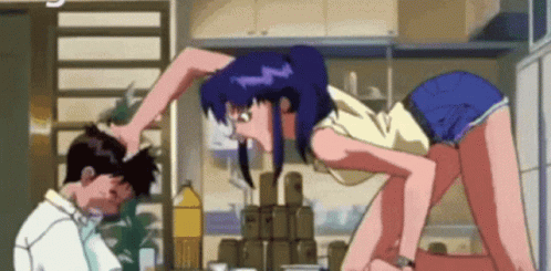 A Man And A Woman Are Standing Next To Each Other In A Kitchen And The Woman Is Holding The Man 'S Head . GIF