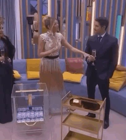 A Man And A Woman Are Standing Next To Each Other In A Living Room . GIF