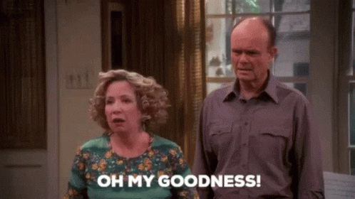 A Man And A Woman Are Standing Next To Each Other In A Living Room . GIF
