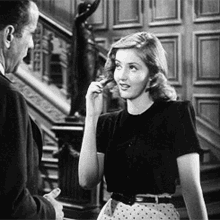 A Man And A Woman Are Standing Next To Each Other In A Room . GIF
