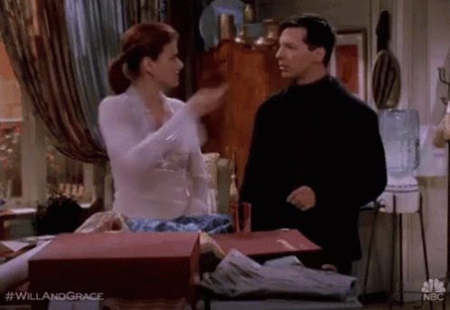 A Man And A Woman Are Standing Next To Each Other In A Room And Talking . GIF