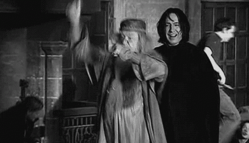 A Man And A Woman Are Standing Next To Each Other In A Room In A Black And White Photo . GIF