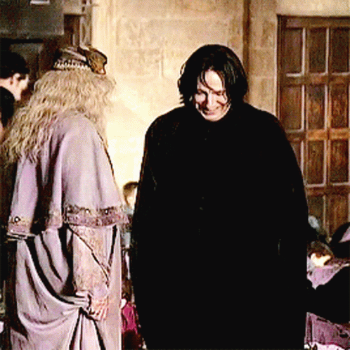 A Man And A Woman Are Standing Next To Each Other In A Room GIF