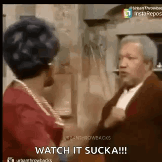 A Man And A Woman Are Standing Next To Each Other In A Room . GIF