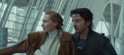 Man And Woman Standing Next To Each Other At Airport GIF