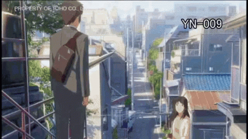 A Man And A Woman Are Standing Next To Each Other In Front Of A City Street . GIF