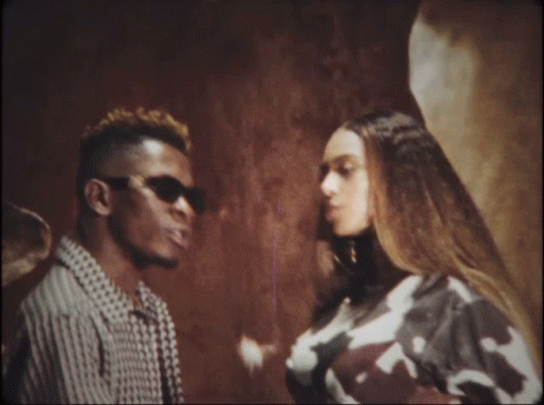 A Man And A Woman Are Standing Next To Each Other Looking At Each Other GIF