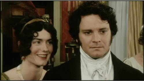 A Man And A Woman Are Standing Next To Each Other GIF