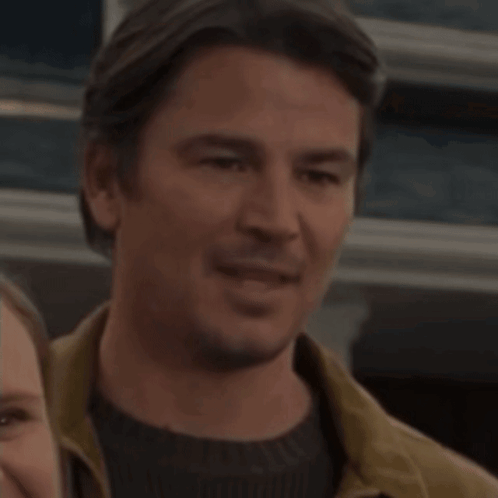 A Man And A Woman Are Standing Next To Each Other GIF