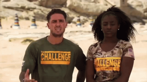 A Man And A Woman Are Standing Next To Each Other On A Beach Wearing Shirts That Say Challenge . GIF